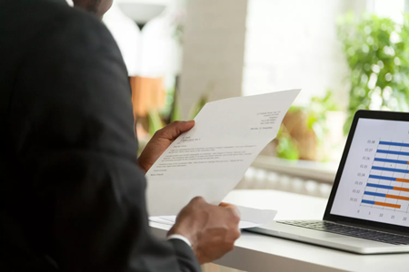 image of a person looking at their resume and laptop
