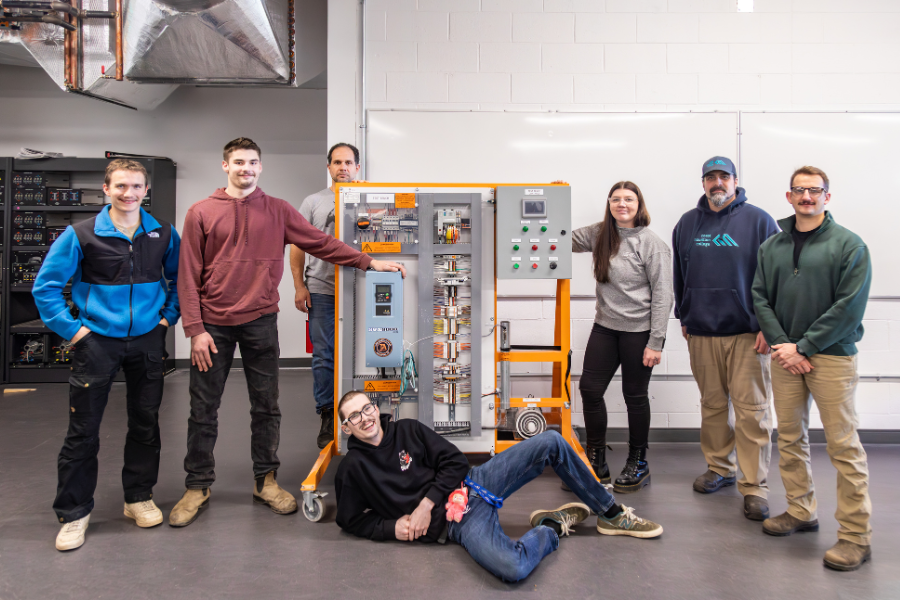 Electrical students and instructors stand with the new electrical test bench donation.