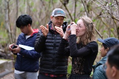 A student of the field school takes measurements under the guidance of one of the instructors.