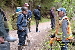 The field school group meets a worker on the side of a dirt road.